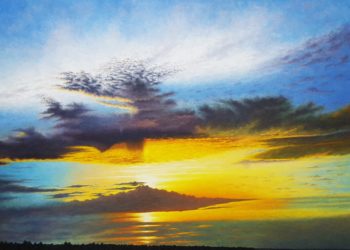 Atardecer manchego, muy visibles en esta zona a la puesta del sol, con esos azules, amarillos y naranjas dándole una despedida al sol en el blanco del cielo.