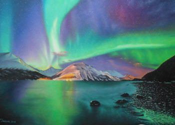 Aurora boreal con azules, verdes y violetas tan característicos, con los cielos plagados de estrellas, destacando el reflejo de la ciudad sobre las montañas.