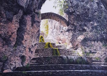 Fuente de Riópar Viejo, en la sierra de Alcaraz, viendo como entra la luz entre las rocas, con el agua saltando por la superficie inferior del lienzo.